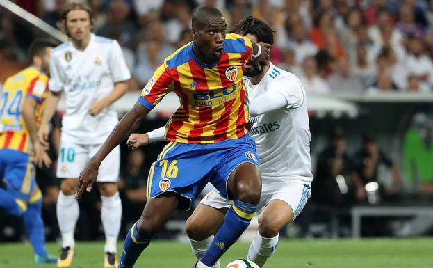 Kondogbia conduce el balón ante la presencia de Isco