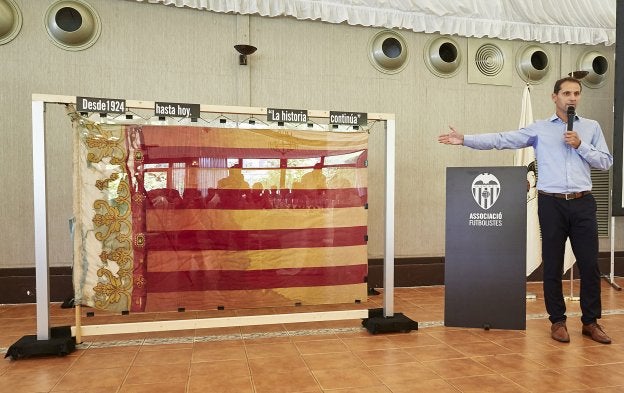 Giner muestra la bandera por el lado en el que luce la Senyera.