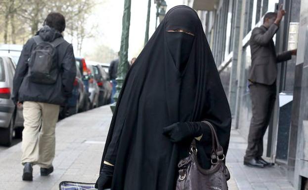 Una mujer vestida con un 'burka' camina por las calles de Bruselas.