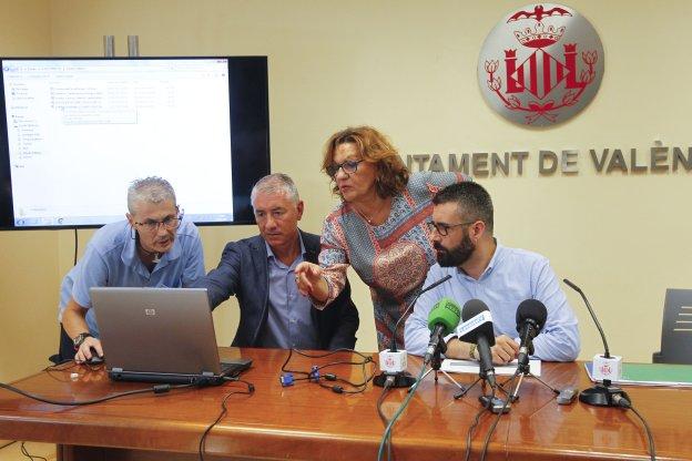 El concejal Fuset (d) observa la encuesta en un portátil durante su presentación.