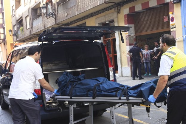 Servicios sanitarios retiran el cuerpo del fallecido de la escena del crimen.