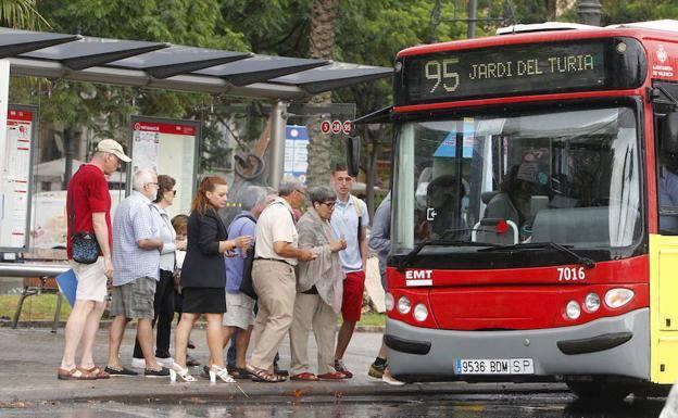 Un grupo de usuarios cogen un autobús de la línea 95 junto al río.