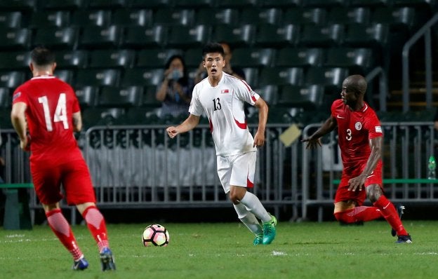 Han controla el esférico entre dos rivales en un partido de su selección.