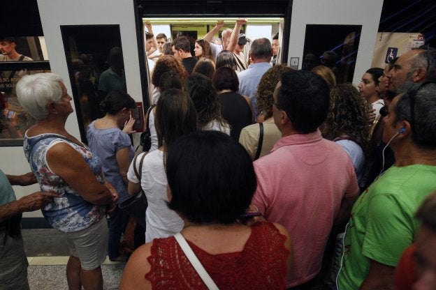 Decenas de personas esperan para subir al tren, ayer en una estación de metro.