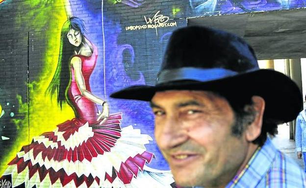 Flamenco en las calles. Ramón Santiago, con su amigo Miguel al fondo, delante de un mural en el que aparecen una bailaora y Paco de Lucía./Ignacio Pérez