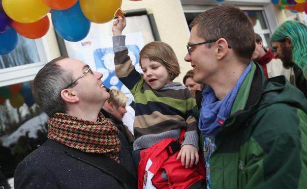 Michael y Kai Korok, con el niño adoptado./AFP