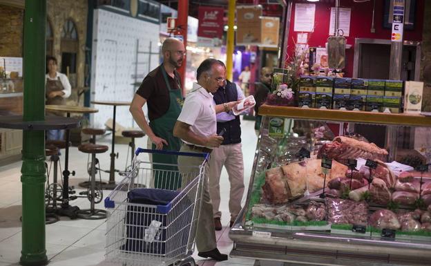 Un empleado de Amazon Prime Now hace compra productos frescos para un cliente en el Mercado de la Paz de Madrid./Óscar Chamorro