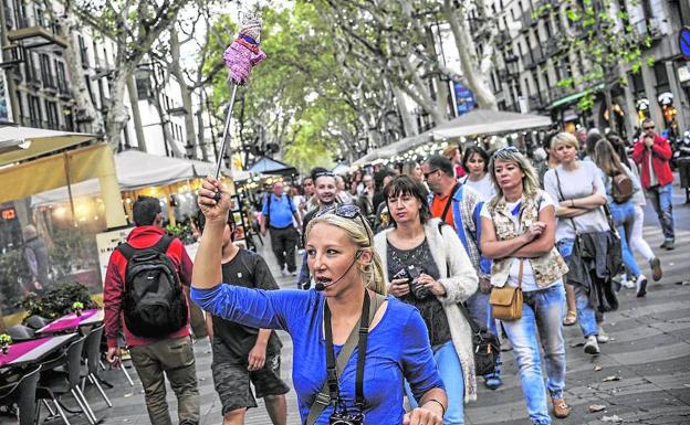 Una guía señala el camino a un grupo de turistas en la siempre masificada Rambla de Barcelona. :/: Ignacio Pérez