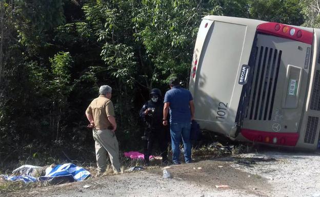 Dos hombres observan el autobús accidentado./Manuel Jesús ORTEGA (Afp)