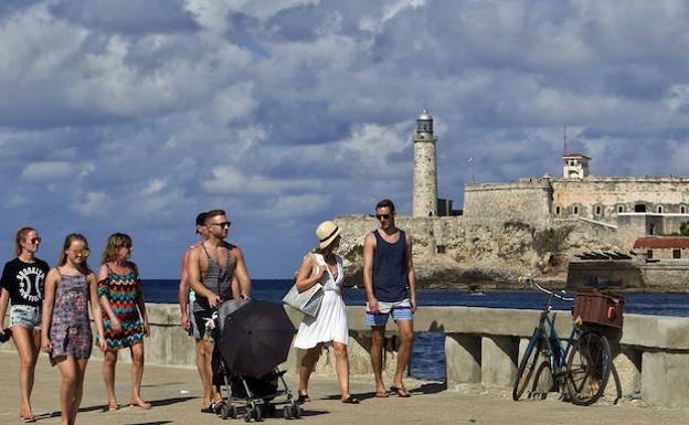 uristas caminan por el Malecón habanero. /Ernesto Mastrascusa (Efe)