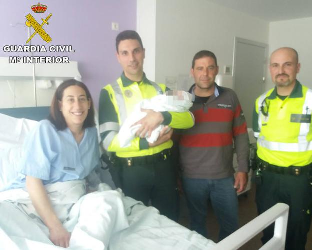 El recién nacido, con sus padres y los guardias civiles que los asistieron, posan en el hospital La Fe./G. C.