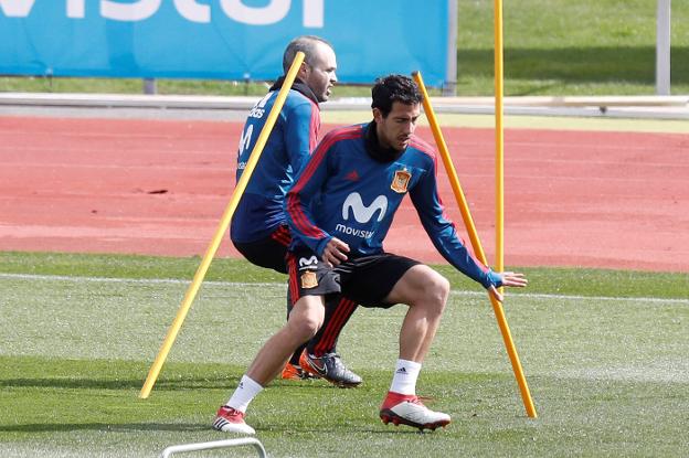 Parejo esquiva unas picas, seguido de Iniesta. / EFE/Juan Carlos Hidalgo