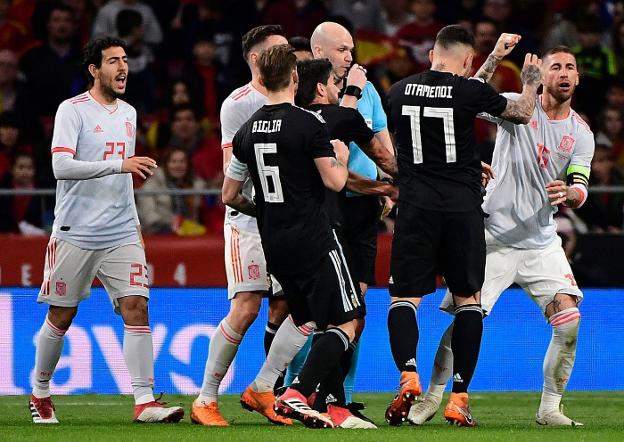 Parejo, a la izquierda de la imagen, protesta una dura entrada realizada sobre Koke. / AFP PHOTO / PIERRE-PHILIPPE MARCOU