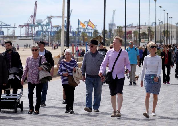 Viandantes por el paseo marítimo de Valencia / reuters