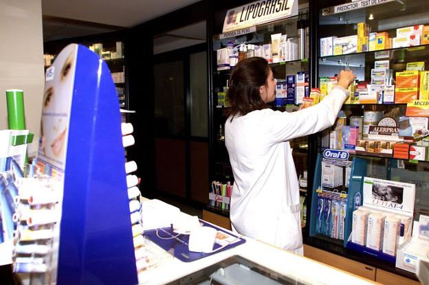 Una farmacéutica organiza medicamentos en su establecimiento. / LP