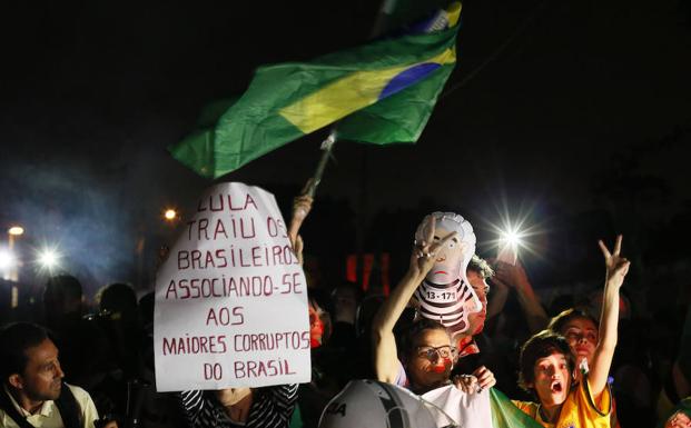 Detractores del expresidente brasileño Luiz Inácio Lula da Silva se concentran frente a la sede de la Policía Federal. /Hedeson Alves (Efe)