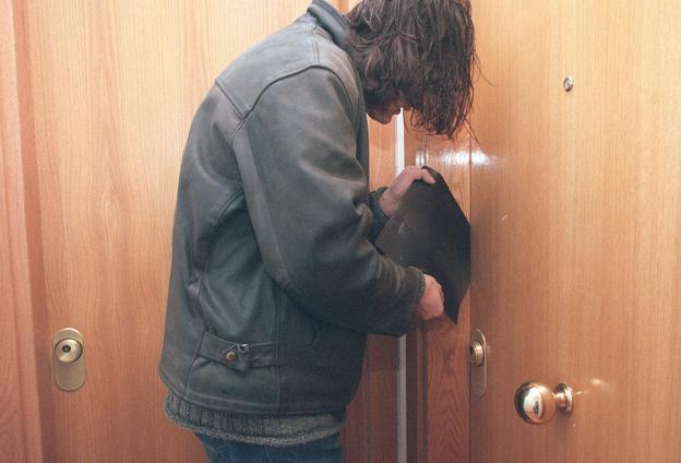 Simulación de un hombre intentando forzar una puerta con una radiografía. /LP