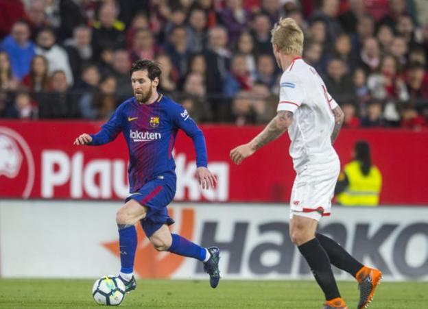 Messi, ante un jugador del Sevilla. /