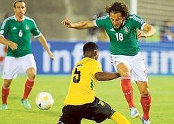 Andrés Guardado supera a Alvas Powell en el Jaimaica-México. / AFP Photo/