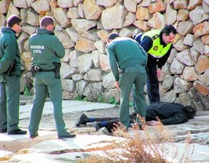 Agentes de la Guardia Civil y la Policía Local, ayer, junto al cuerpo sin vida de la víctima de Vinaròs. :: EFE. JULIO VIDAL/