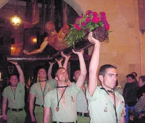 La imagen del Cristo Yacente portada por los legionarios saliendo del Palau Ducal. ::
LP/
