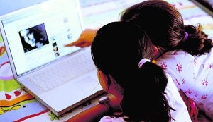 Dos niñas realizan una consulta en internet a través de un ordenador portátil. :: LP/