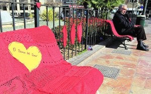 Un hombre se siente en una de las colchas hechas ayer por las 'Urban Knitting'. :: JUAN JOSÉ MONZÓ/