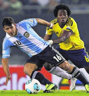 Carlos Sánchez trata de
impedir el control del Kun
Agüero. ::
REUTERS/