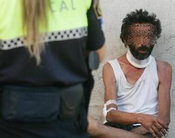 AUXILIO. Una policía ayuda a un mendigo. / DAMIÁN TORRES/
