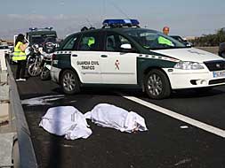 Los cuerpos del matrimonio fallecido en Alicante, tapados con sábanas, junto a un coche de la Guardia Civil./