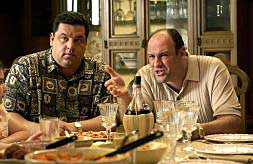 James Gandolfini (d), en una escena de la serie 'Los Soprano', sentado a la mesa./
