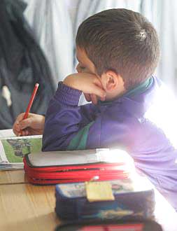 Un niño toma notas durante el transcurso de una clase./
