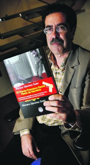 Sánchez Soler muestra un ejemplar de su libro. /ALEX DOMÍNGUEZ/