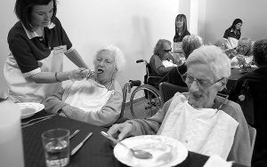CUIDADOS. Una mujer da de comer a ancianos en la residencia Novaedat de Xàtiva. / DANIEL DUART/