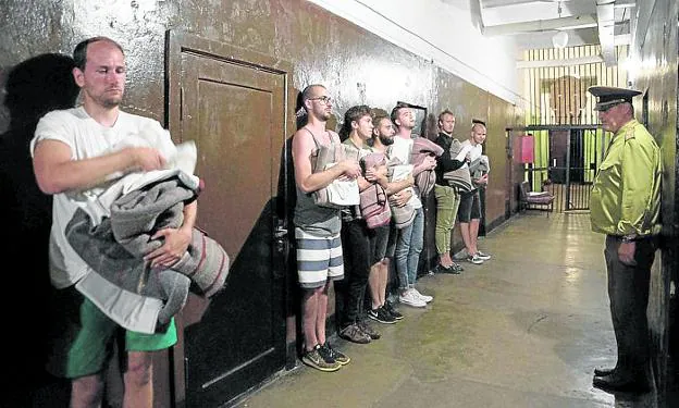 Cárcel de Karosta. Un grupo de turistas que se han atrevido a pasar la noche como reos son inspeccionados por el oficial de turno./ karosta prison