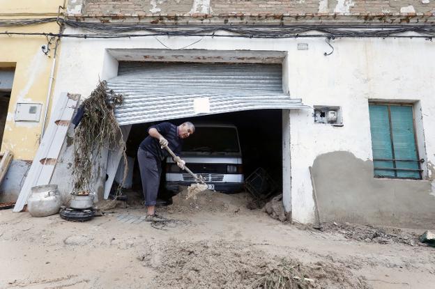 Un vecino saca el barro acumulado tras las lluvias de septiembre. / irene marsilla