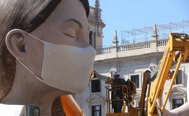 Una mascarilla anticoronavirus cubre la cara de la figura central de la falla municipal. /Damián Torres