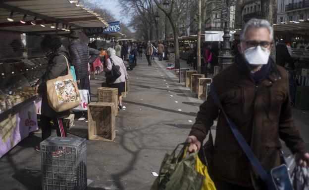 Un comprador se protege con una mascarilla en un mercado al aire libre en París el pasado domingo