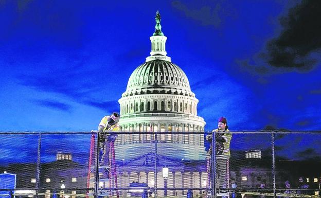 Operarios instalan una valla de seguridad de alta resistencia en torno al Capitolio durante los preparativos para el acto de investidura de Biden./reuters