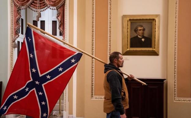 Un seguidor de Donald Trump en el Capitolio de EE UU con una bandera de los Estados Confederados /EFE