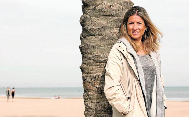 Lorena Oliver, apoyada en una de las palmeras en la playa./DAMIÁN TORRES