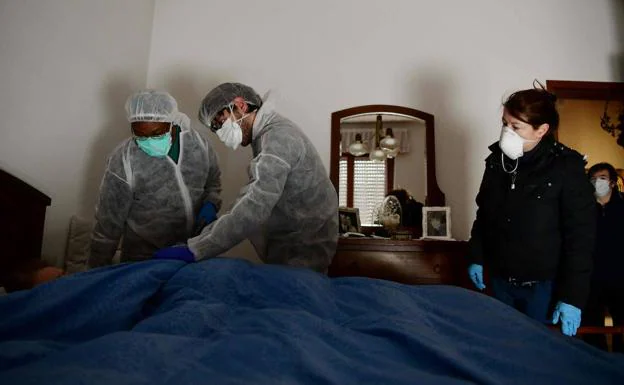 Miembros de los equipos sanitarios de Bergamo visitan en marzo del pasado año a una anciana de 80 años presuntamente contagiada. /AFP