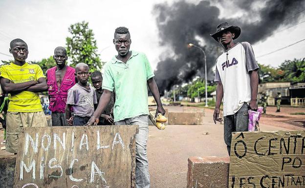 Un grupo de jóvenes muestran su enfado junto a una barricada en llamas tras el ataque perpetrado contra una iglesia./AFP