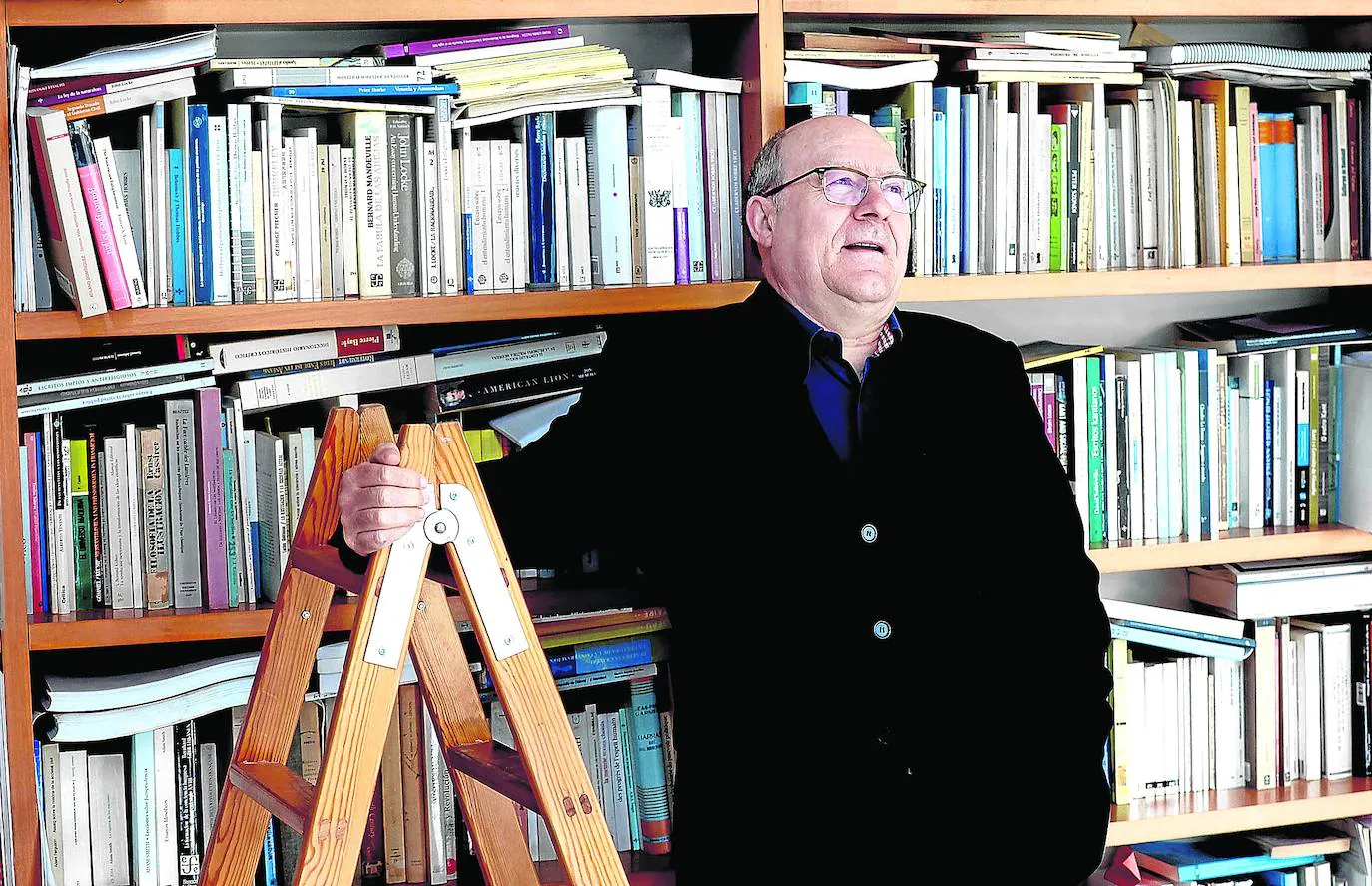 José Luis Villacañas posa ante la bien nutrida biblioteca de su casa./JESÚS SIGNES