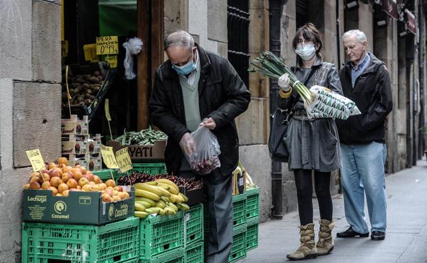 Ciudadanos comprando fruta en una tienda en Bilbao. /BORJA AGUDO