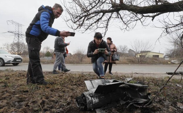 Ciudadanos fotografían los restos de un misil disparado contra Ucrania.  /EFE/SERGEY DOLZHENKO