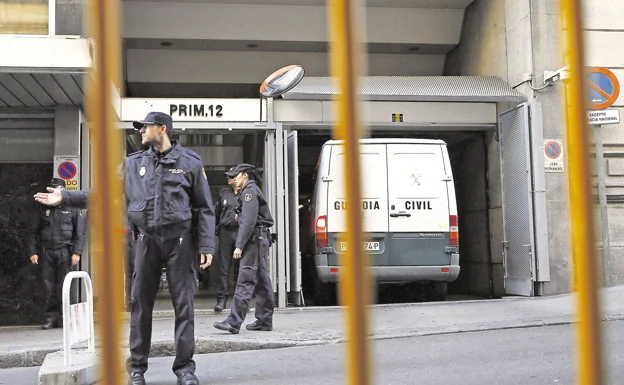 La Policía Nacional espera junto a una furgoneta en la puerta de la Audiencia Nacional. 