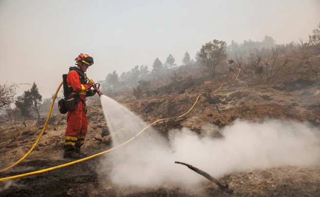 Un bombero extinguiendo el incendio de Bejís en una fila. 