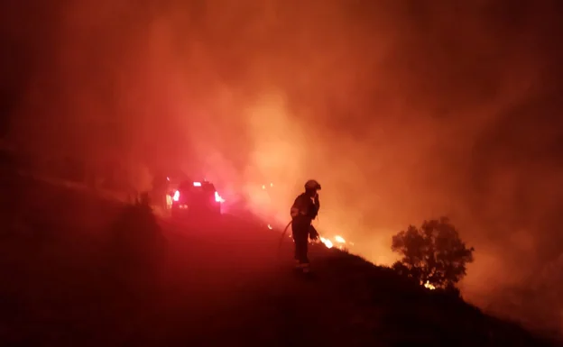 Un bombero trabaja para apagar las llamas del incendio de Bejís. 